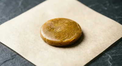 Goldbraune, butterartige Piatella Hash Scheibe auf Pergamentpapier mit glänzender Oberfläche